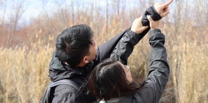 Two members of BTPC outdoors, one pointing towards the sky
